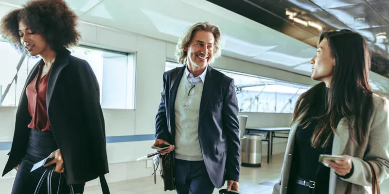 Business travellers smiling as they walk through an airport